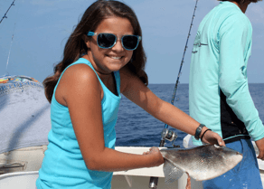 Young girl holding triggerfish during a wreck fishing charter.