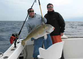 Two charter anglers at transom holding up a winter tilefish.