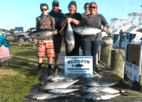 Group standing behind their catch at docks after an affordable family friendly fishing charter.