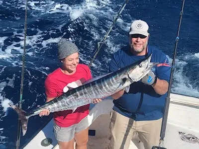 Young lady angler and mate holding a nice wahoo